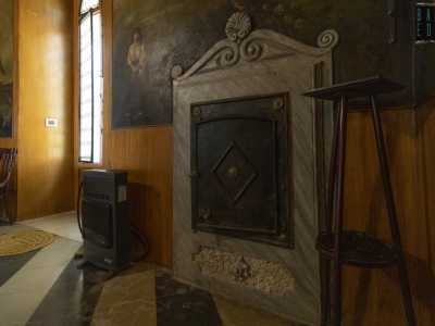 Sui lati della stanza scoviamo anche un piccolo focolare, celato da un�anta in ghisa